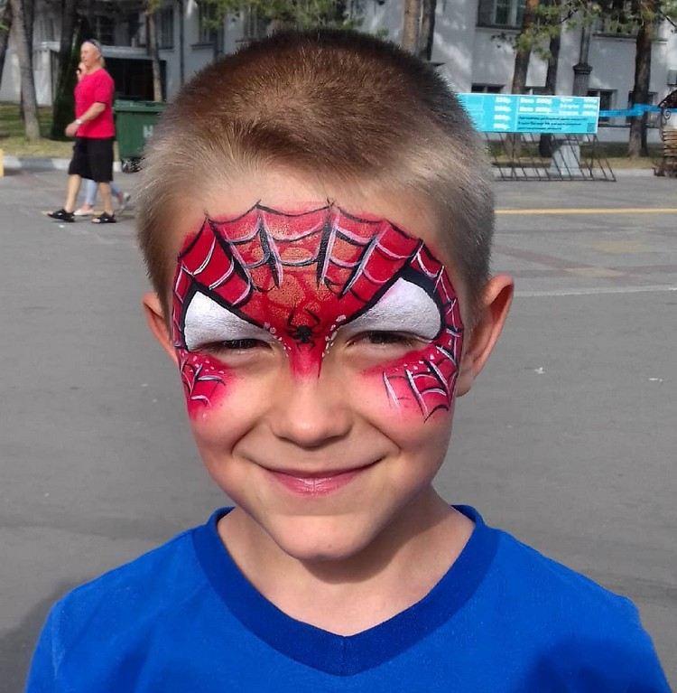 copil ca spiderman aplicând machiaj Halloween petrecere pentru copii