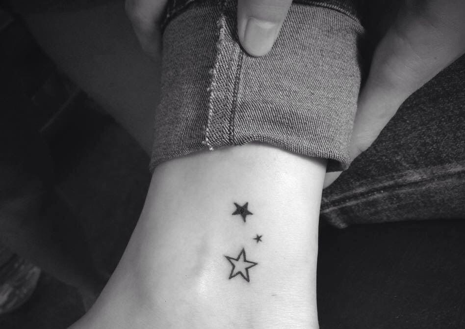 Tatuagem de três estrelas na perna