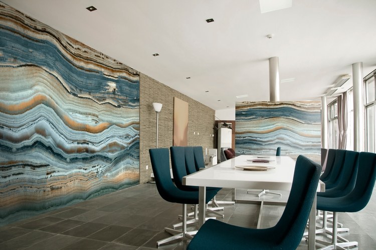 accente colorate de culoare pe pereții de piatră în combinație cu scaune albastre din sufragerie