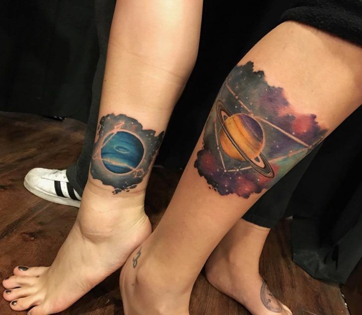 Tatouage sur le thème de l'espace coloré sur la jambe