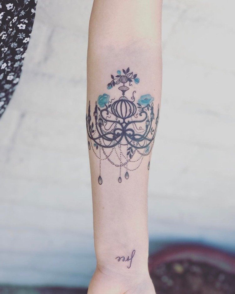 Candelabru cu lanțuri și pietre prețioase flori albastre antebraț în interiorul femeii