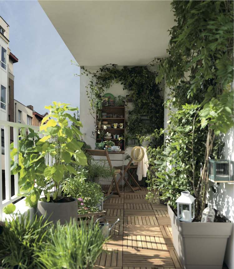 Balcon verde luxuriant, cu pardoseală așezată cu gresie din lemn și mobilier de exterior funcțional din lemn masă-balcon-exterior-gresie-lemn-plante-plante-lemn-pliant-scaun-masă pliantă