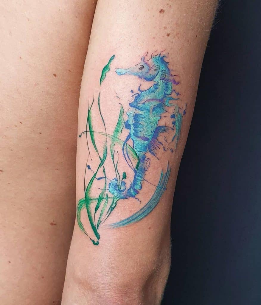 Tatouage d’hippocampe bleu vif sur le bras
