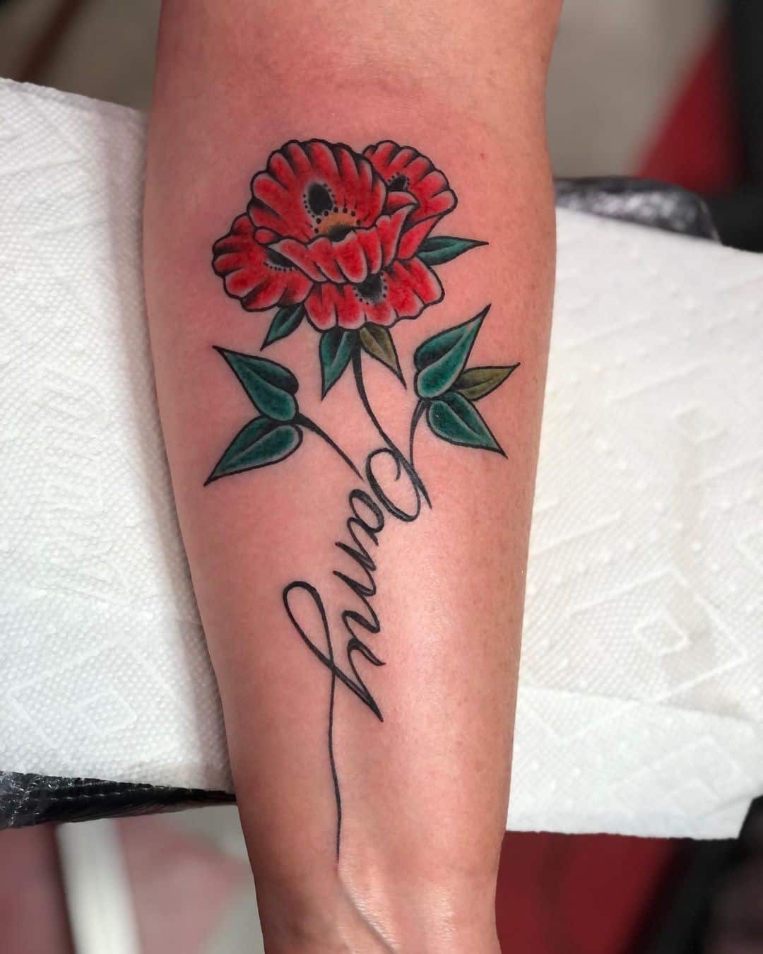 名前タグ付きの赤いポピーの花のタトゥー