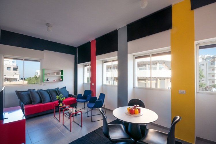 Culorile tipice pentru stilul Bauhaus sunt galben, albastru și roșu trăind în stilul bauhaus living-zonă de luat masa-culori-roșu-galben-albastru-gri-modern