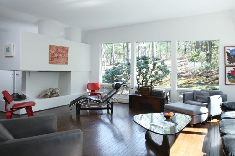Locuință elegantă cu un șezlong LC4 din piele și o măsuță de cafea din sticlă living-in-the-bauhaus-style-living-room-coffee-table-triangle-chemine-red-accents