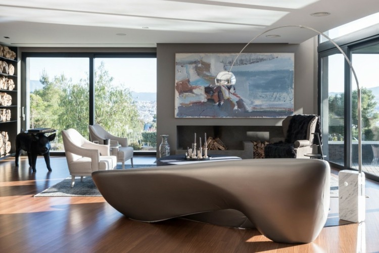 Livingul negru și gri are o zonă de relaxare cu o canapea lângă șemineu sufragerie apartament gri negru zonă de relaxare șemineu fotoliu mural alb