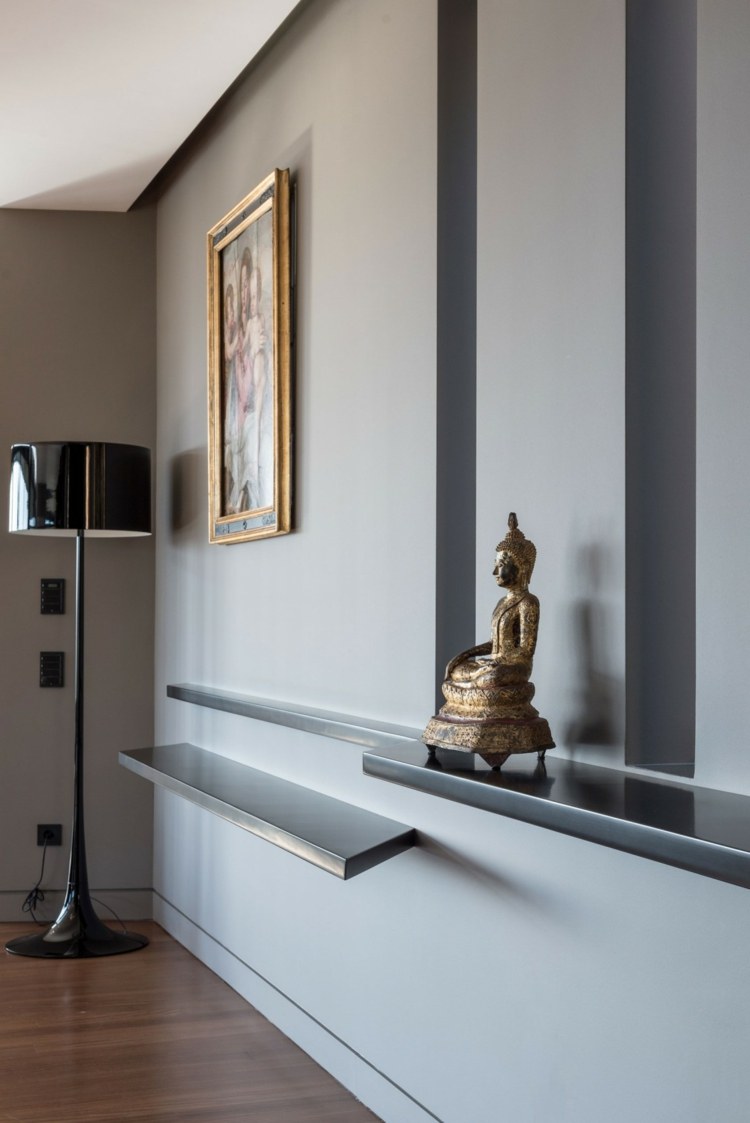 Accente gri în camera de zi sub formă de rafturi sufragerie gri negru apartament buddha figura perete raft lampă de podea