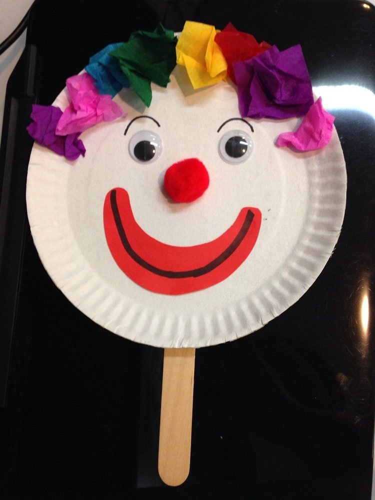 Clown joacă păpușă pentru carnaval din farfurii de hârtie și bastoane de gheață